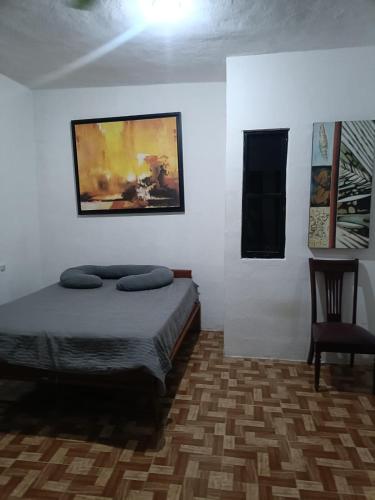 a bedroom with a bed and a painting on the wall at Casa Albino in Izamal