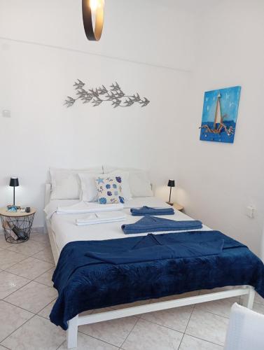 a bedroom with a large bed with a blue blanket at Konstantinos in Chorto