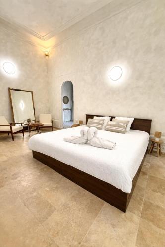 a bedroom with a large bed with white sheets at MEEY Suite with Private Spa in Saint-Étienne