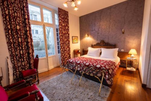 a bedroom with a bed and a large window at Villa l'Orante in Lourdes
