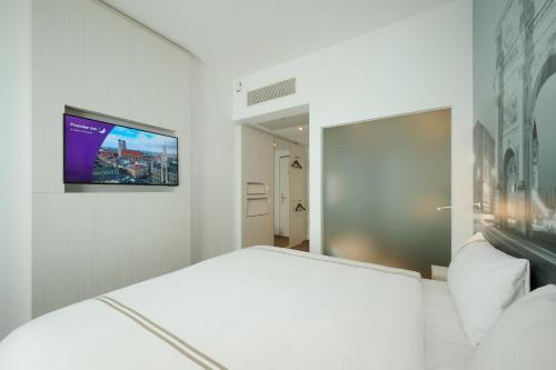a bedroom with a bed and a tv on the wall at Premier Inn München City West in Munich