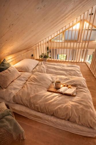 a large bed with a tray of food on it at SeeLaVie - Tiny Houses am Mattsee in Mattsee
