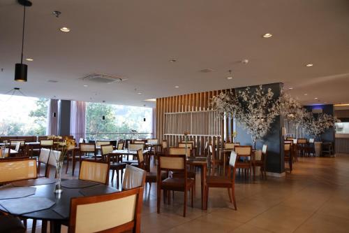 a dining room with tables and chairs in a restaurant at Grand Suítes Family Resort in Itá
