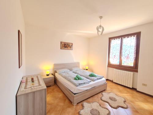 a bedroom with a bed and a table and a window at Villa La Pief - Gardasee by Garda Domus Mea in Tremosine Sul Garda