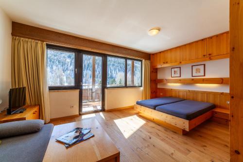 a bedroom with a bed and a large window at Alpina Residence in Solda