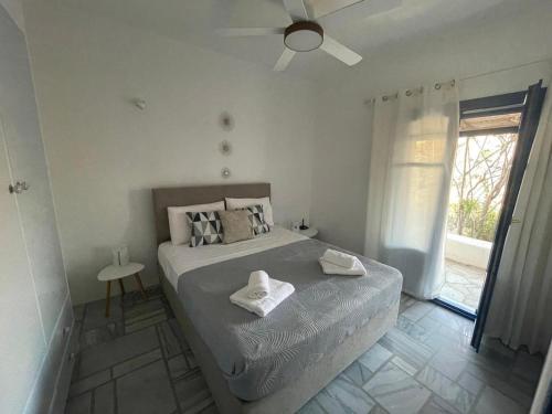 a bedroom with a bed with two towels on it at Dejableu - Island Living Paros in Sarakíniko