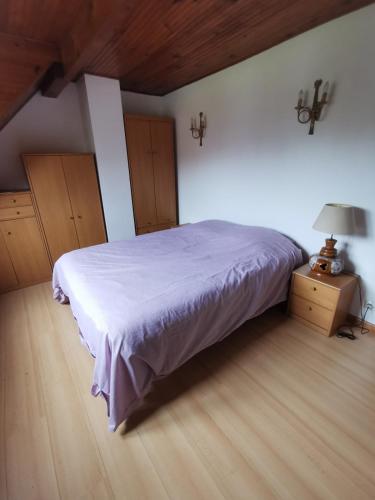 a bedroom with a bed and a lamp on a wooden floor at Le Chant des Grenouilles in Itteville