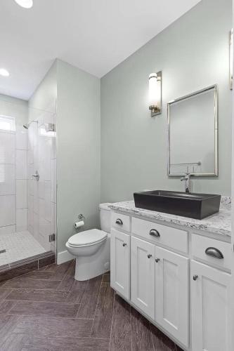 a bathroom with a sink and a toilet and a mirror at Azalea & Blackberry Cabins in Jasper