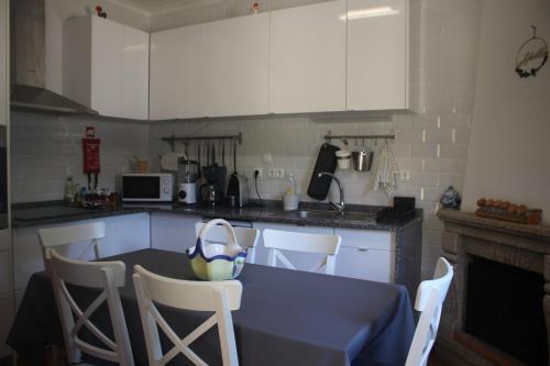 a kitchen with a table and chairs and a kitchen with white cabinets at Casa dos Leme in Baião