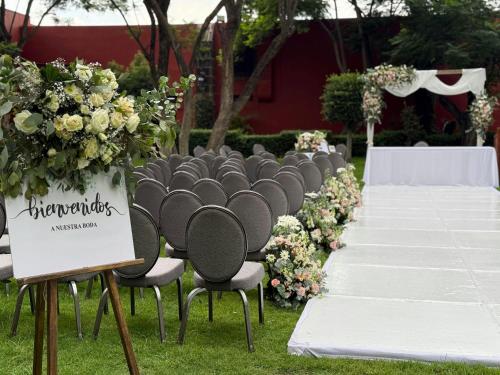a row of chairs with flowers and a aisle at Fiesta Americana Hacienda Galindo Resort & Spa in Galindo
