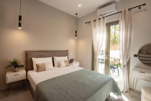 a bedroom with a large bed and a large window at Joanna Holiday Home in Egina