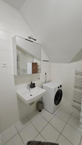 a white bathroom with a washing machine and a sink at Vila Apartment Bled Lake in Bled