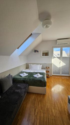 a bedroom with a bed and a couch and a window at Vila Apartment Bled Lake in Bled
