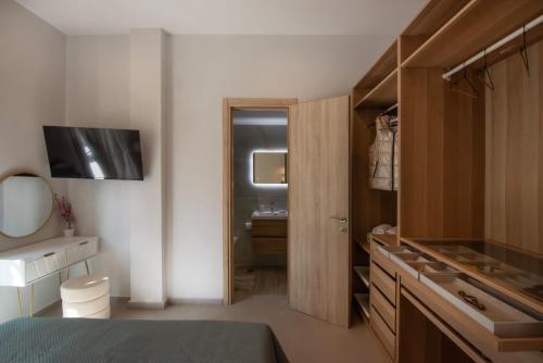 a bedroom with a bathroom with a sink and a bed at Joanna Holiday Home in Egina