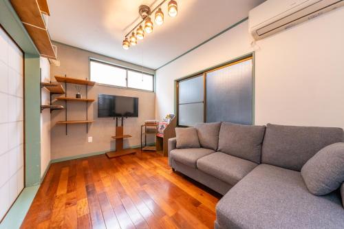 a living room with a couch and a flat screen tv at ON SALE 13 minutes by Haneda Airport train, 15 minutes walking distance by station, fully equipped with a record player, maximum 5 people in Tokyo