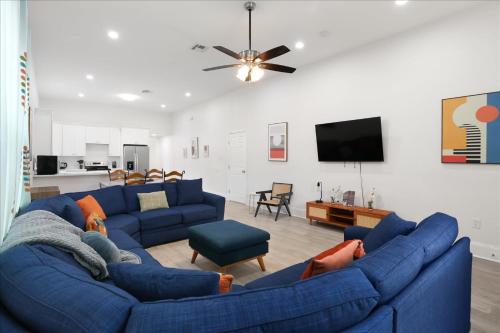 a living room with blue couches and a flat screen tv at Sunny 5Bed w Parking and direct Streetcar access in New Orleans