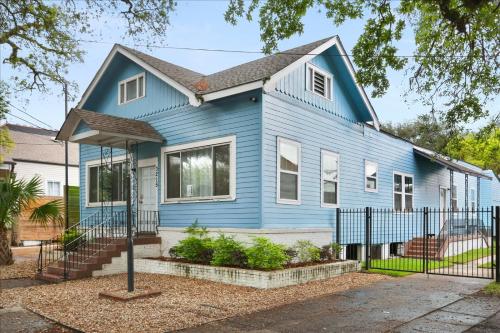 a blue house with a fence in front of it at Sunny 5Bed w Parking and direct Streetcar access in New Orleans