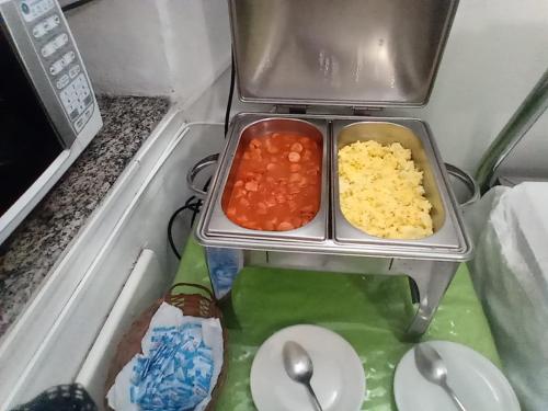 a table with two trays of food on top of a stove at Hotel Pampulha Palace in Belo Horizonte