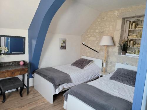 a bedroom with two beds and a desk and a window at Gîtes et Chambres des Coteaux in Sainte-Maure-de-Touraine