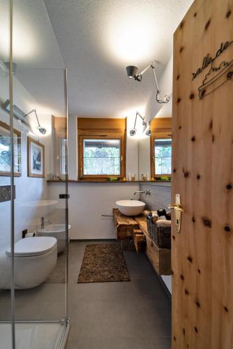 a bathroom with two sinks and a glass door at Chesa Flurigna - Zuoz in Zuoz