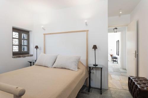 a bedroom with a bed and a white wall at Oxalis Villas in Perlengiánika