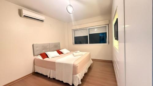 a bedroom with a bed and a window at Apto Dangui Amplo in Santa Maria