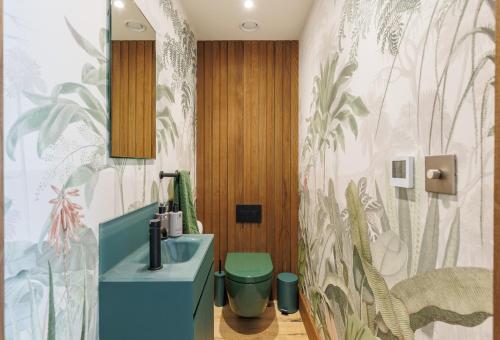 a bathroom with a blue sink and a green toilet at Rena's Retreat - Luxury Architectural Eco Home with hot tub a short walk from Gurnard in Cowes - Perfect Lux Stay for Sailers Couples and Older Families in Gurnard