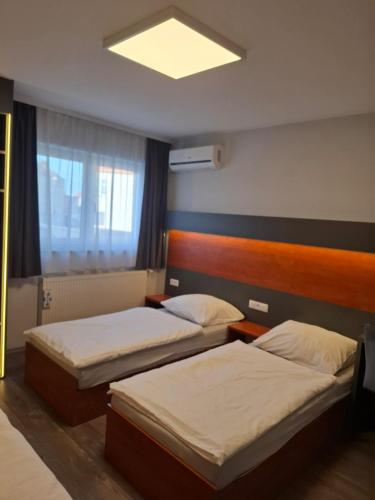 two beds in a hotel room with a window at Ambrozja in Strzelin