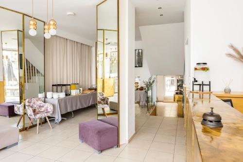 a living room with a table and purple chairs at Coral Hotel - Hotelia Hospitality Group in Ierapetra