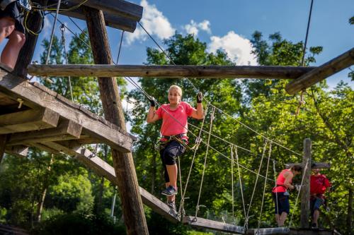 a woman on a zip line at a playground at Arnika in Blatten bei Naters