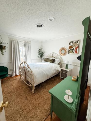 a bedroom with a bed and a green table at The Joyful Escape in Crewe