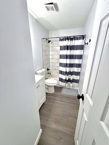 a white bathroom with a toilet and a shower at Crewe Corner Apartment C in Crewe