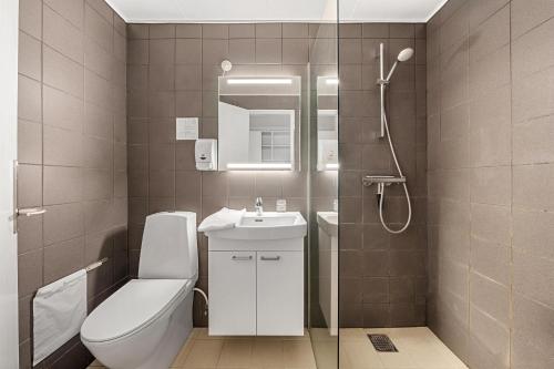 ein Badezimmer mit Toilette, Waschbecken und Dusche in der Unterkunft Hotel Fuglsocentret, BW Signature Collection in Knebel