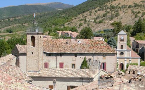 an old building with a clock tower in a village at Château de Rosans in Rosans