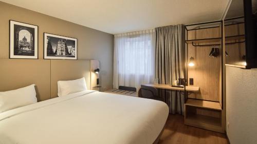 a hotel room with a large bed and a window at Campanile PRIME - Nogent-sur-Marne in Nogent-sur-Marne
