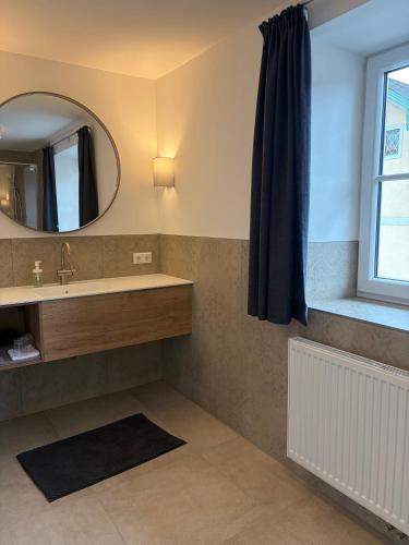 a bathroom with a sink and a mirror at Pension Schiessling in Anif