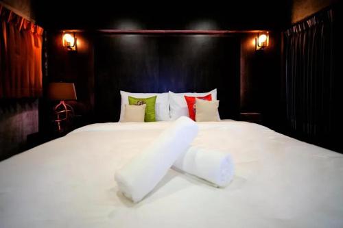 a bedroom with a white bed with two pillows at Photohostel in Bangkok