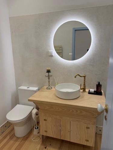 a bathroom with a sink and a toilet and a mirror at Casa da Ana - Casinhas com Alma in Torrão