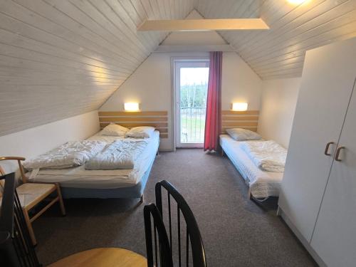 ein Zimmer mit zwei Betten, einem Tisch und einem Fenster in der Unterkunft Læsø Efterskole in Læsø