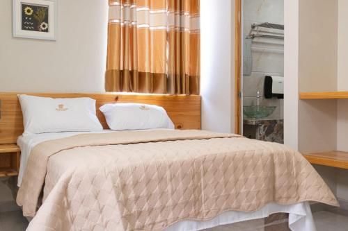 ein Schlafzimmer mit einem Bett mit hölzernem Kopfteil in der Unterkunft Hotel partenon in Tacna
