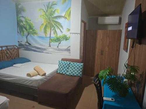 a room with a bed and a couch and a painting at Hotel Casa Pueblo in Ocú