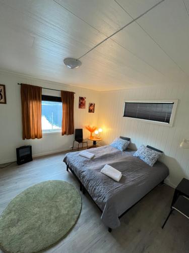 a bedroom with a large bed and a rug at Green apartment in Odda