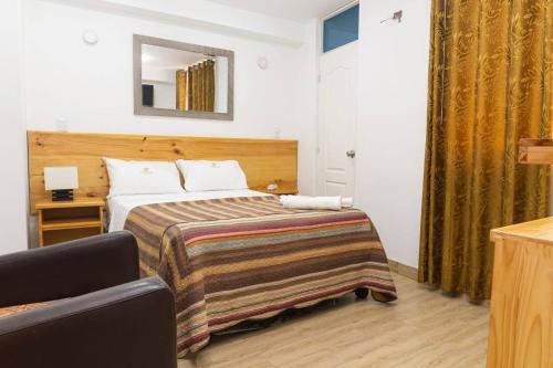 ein Hotelzimmer mit Bett und Spiegel in der Unterkunft Hotel partenon in Tacna