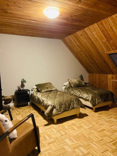 a bedroom with two beds and a wooden ceiling at B&B Aan t End in Kootwijkerbroek