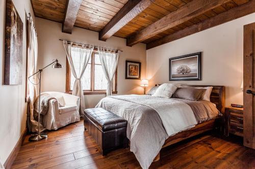 a bedroom with a large bed and a wooden ceiling at Chalet Le Mont-Blanc in Saint-Faustin