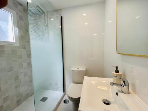 a bathroom with a toilet and a sink and a shower at La casa del pinsapo in Yunquera