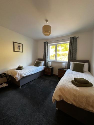 a bedroom with two beds and a window at Antlers Rest in Borve