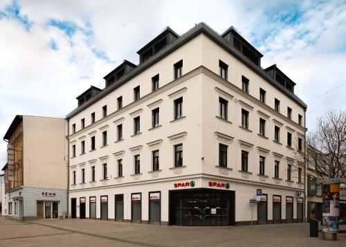 a white building with a lot of windows at Limehome Wels Ringstraße in Wels