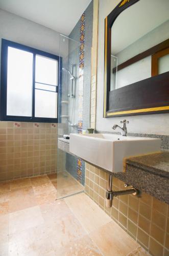a bathroom with a sink and a mirror and a shower at Cocoville Phuket - SHA Plus in Chalong