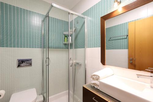 a bathroom with a shower and a sink and a toilet at T3-Sitio do Surf in Nazaré